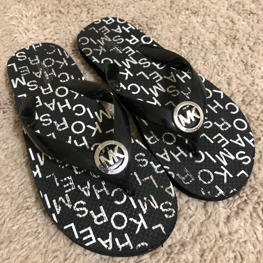 Black and white Michael Kors flip flops.